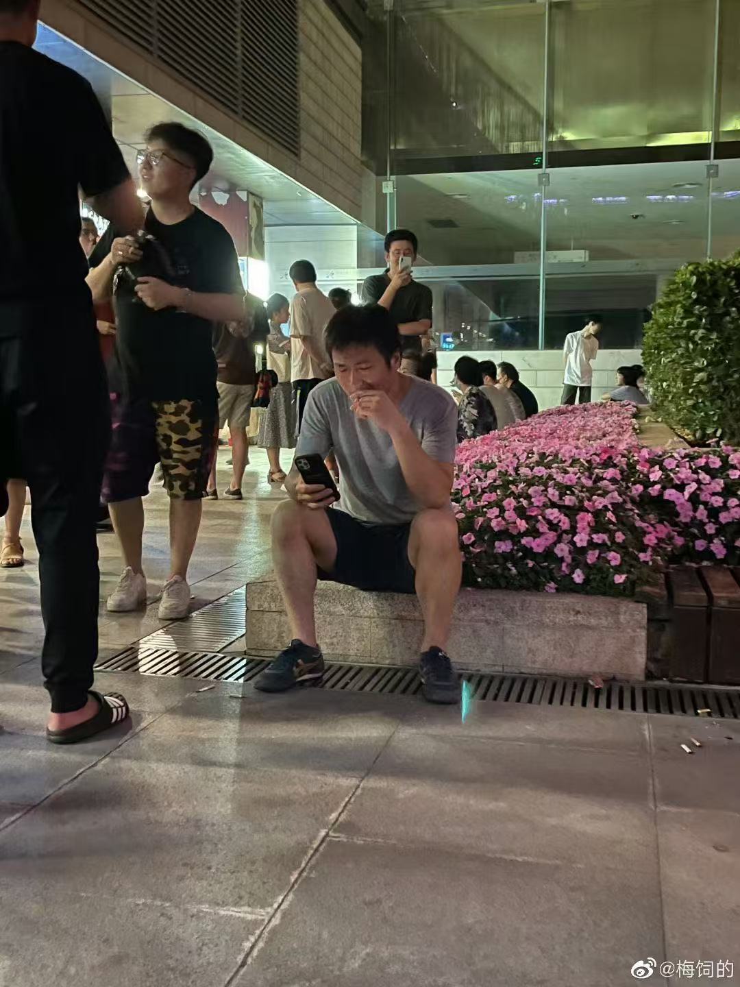 逼哥蹲在路边抽烟玩手机